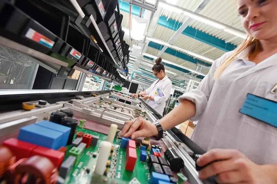 A wide shot of a PCB assembly factory with various machines and workers.
