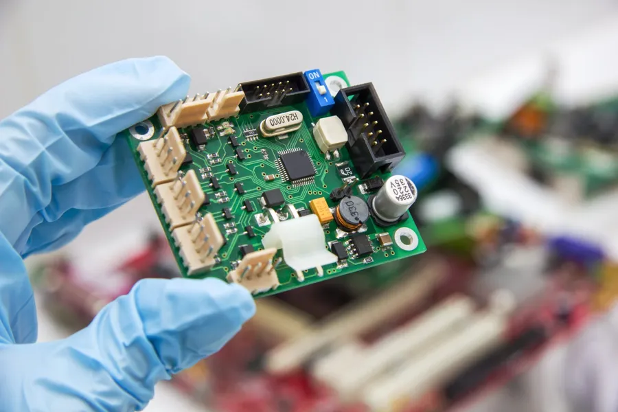 A green printed circuit board with electronic components.