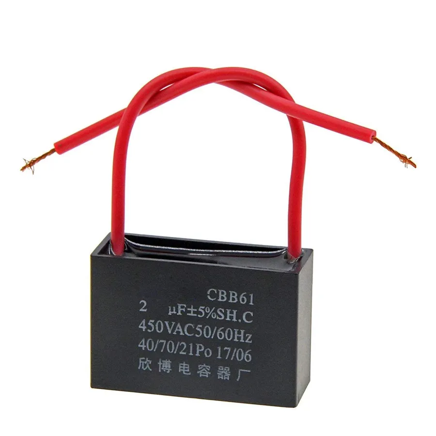 A close-up of a capacitor connected to an electric fan motor.