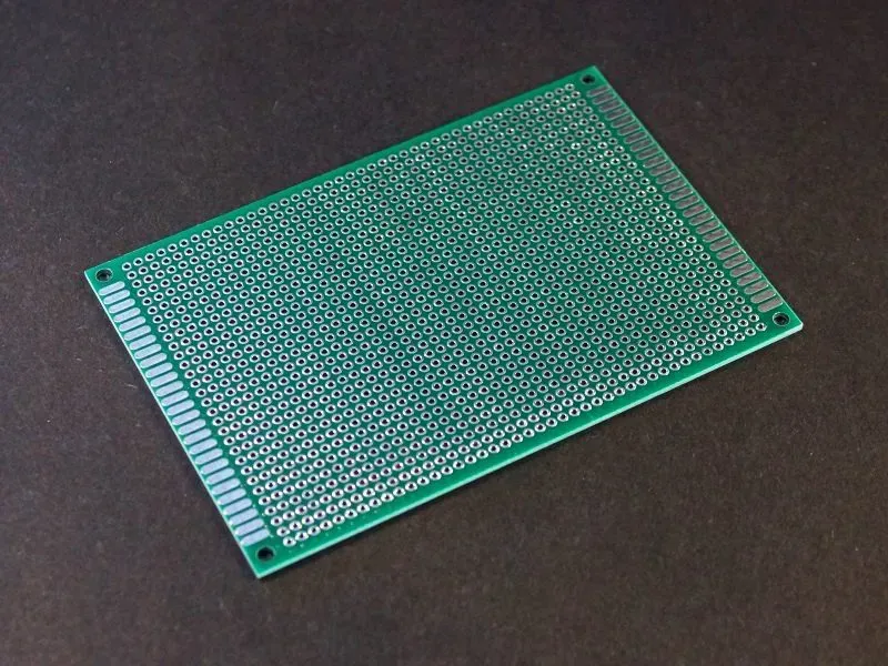 A physical prototype circuit board for a router, held by a hand.